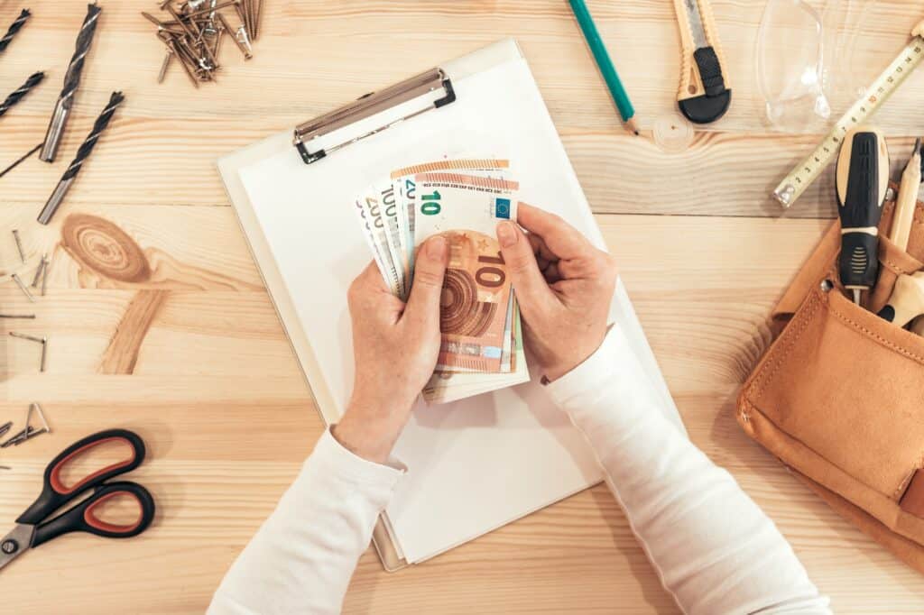 Female carpenter counting money, top view